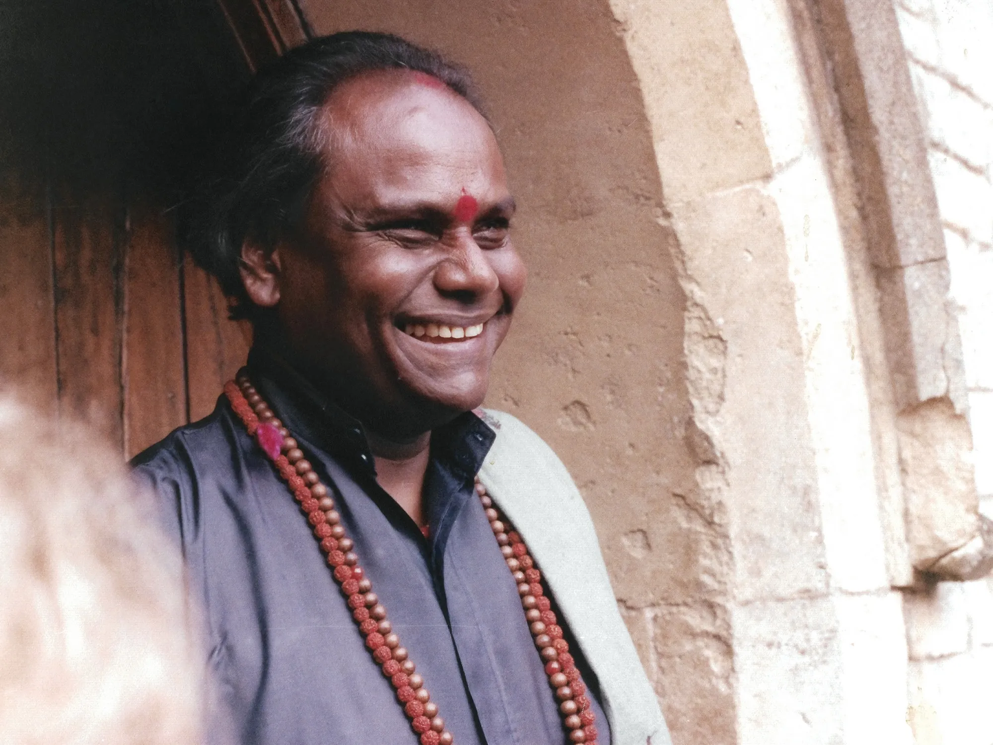 Guru laughing in a doorway